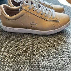 Woman’s gold colored la coste gold sneaker